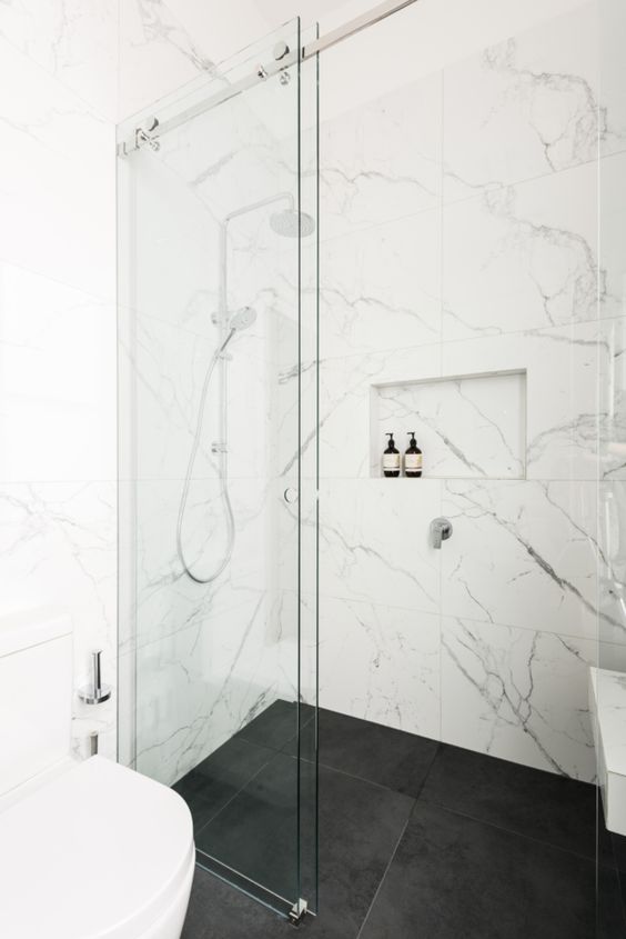 beautiful white marble tiles on the walls and black matte tiles on the floor create a stylish and timeless combo