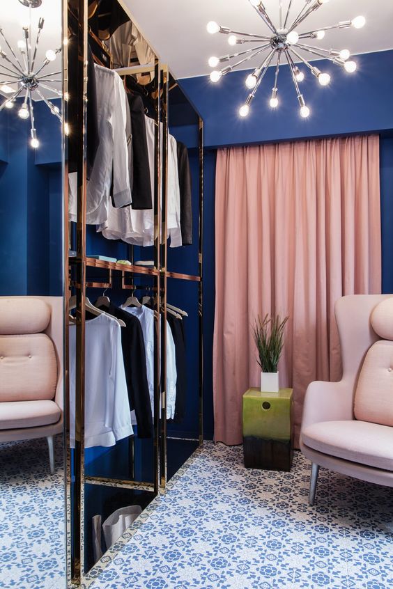 A navy closet with pink drapes and neutral furniture plus metallic touches looks very glam like
