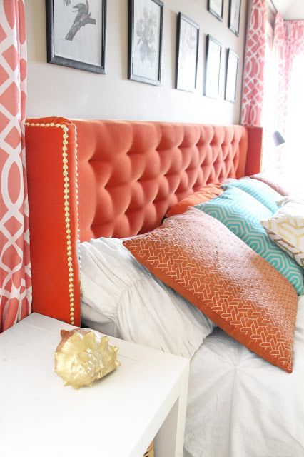 add a touch of color with a coral tufted headboard and decorative nails for a bold look