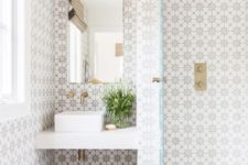 26 chic patterned mosaic tiles on the walls and neutral light grey ones on the floor plus brass accents