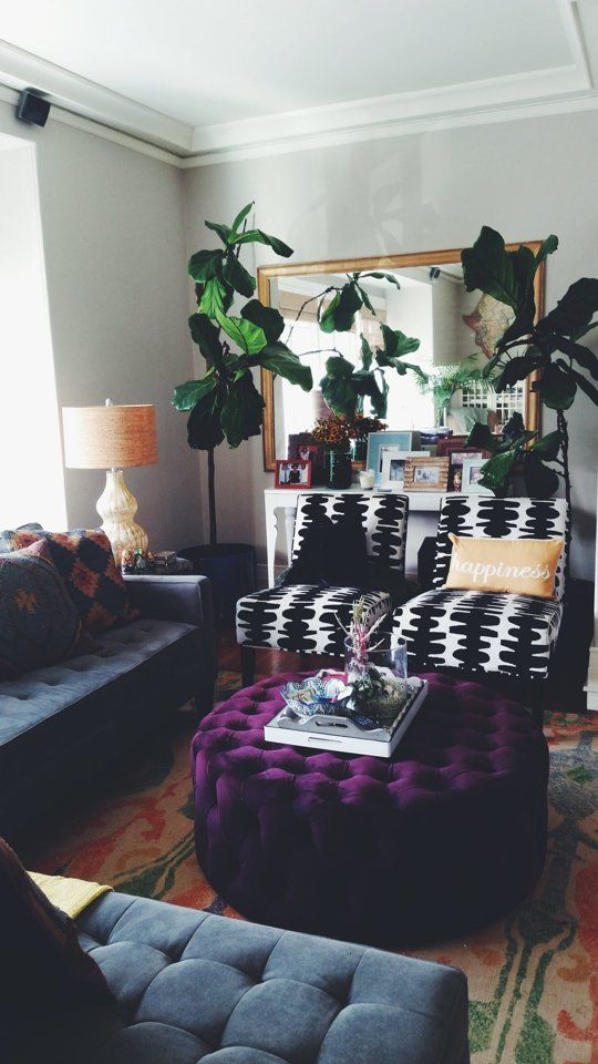 a plum-colored tufted velvet ottoman with hidden storage adds color to the space