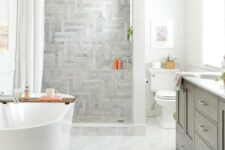 a beautiful farmhouse bathroom with various tiles, a grey vanity, a curtain and an oval tub plus white appliances
