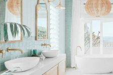 a bright and airy coastal bathroom with mint green tiles, a floating vanity, an oval tub, a woven pendant lamp and some lamps