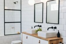 a mid-century modern bathroom with long grey tiles and white square ones, black frames and a floating vanity with two sinks