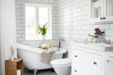 a modern farmhouse bathroom with white subway, blue mosaic tiles, a white vanity, a mirror cabinet and a clawfoot tub