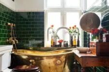 a small vintage bathroom with green subway tiles, a vintage stained vanity, artwork and a mirror, blooms and some decor
