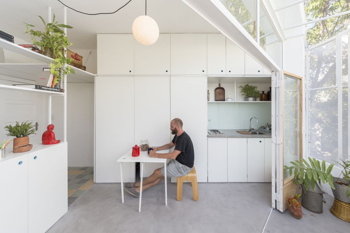 The apartment features a white sleek kitchen with a small eating space that can be hidden