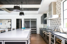 02 The kitchen is done with stainless steel cabinets and appliances, there are mosaic walls
