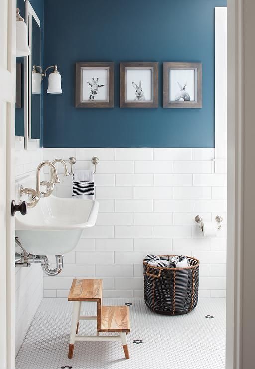 a contemporary bathroom with walls partly painted blue and partly clad with white tiles