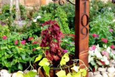 02 a garden post with a hanging planter and elegant metal house numbers is a stylish vintage-inspired idea