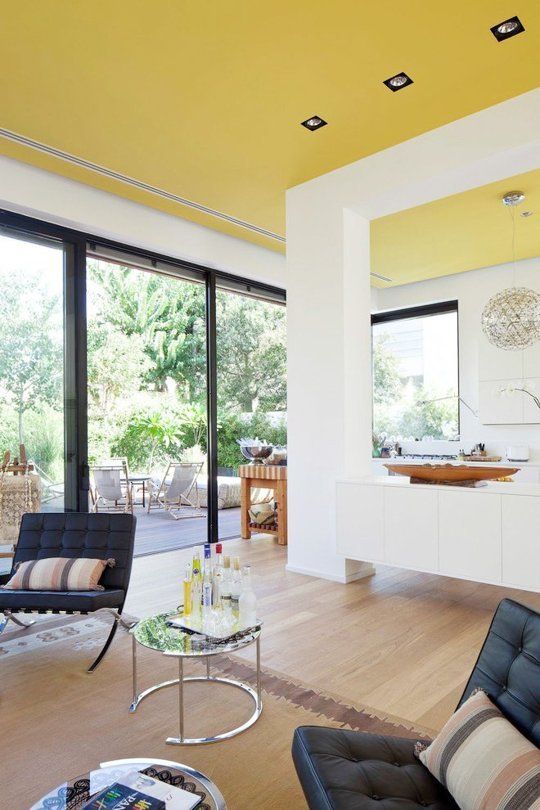 An unexpected sunny yellow ceiling creates a feeling of sunshine in the house everytime you look at it