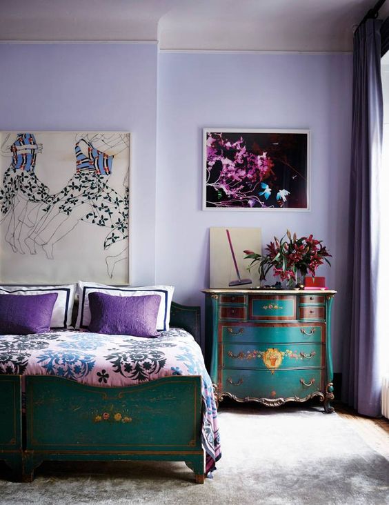 a bold bedroom with lilac walls, turquoise and emerald furniture and purple and pink details