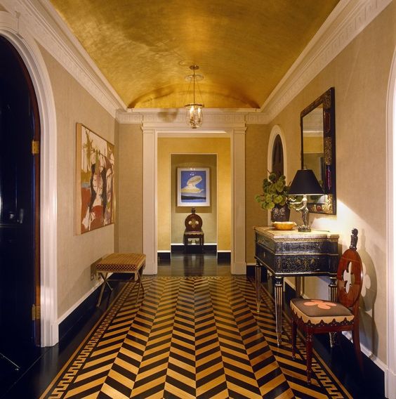 a bold mid-century modern foyer with a metallic arched ceiling and a bold chevron floor