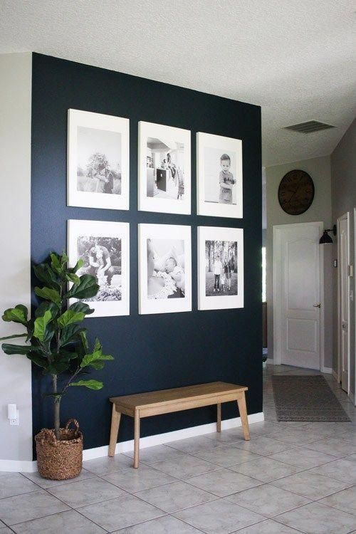 a statement navy wall with a gallery wall of black and white family photos