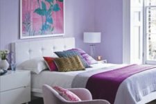 04 a bright bedroom with lilac walls, a pink chair and bright bedding and pillows is a great place to wake up