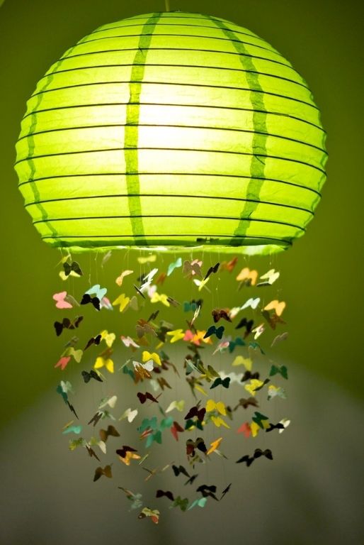 a colorful Regolit lampshade with some paper butterflies attached is a whimsical decoration