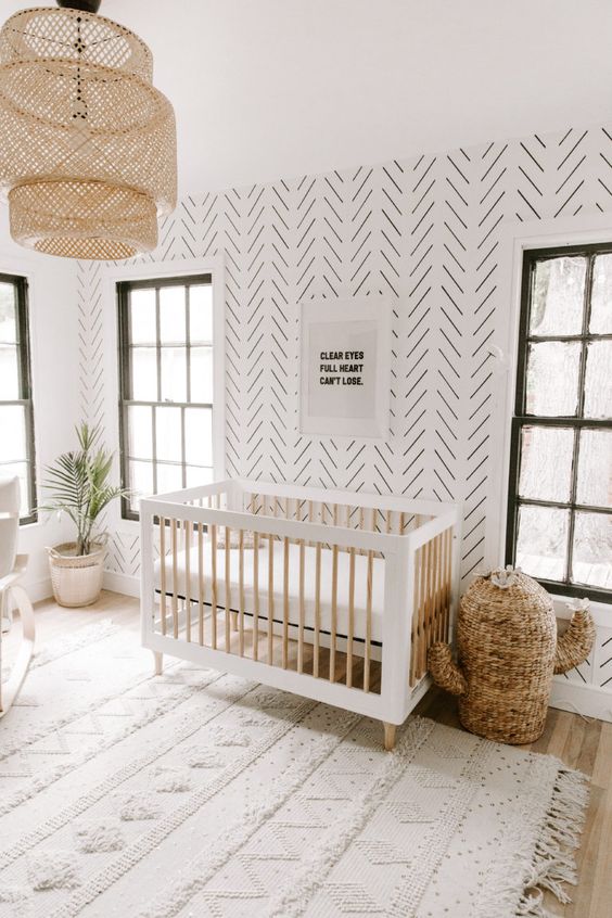 a gender-neutral minimal boho nursery with a printed statement wall that looks bold