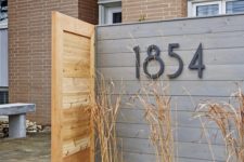 04 house numbers placed on the wood plank wall in the front yard space is a cool idea