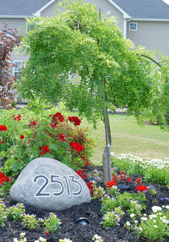 integrate your house numbers in landscaping placing them on a large rock on your lawn or in the front yard garden