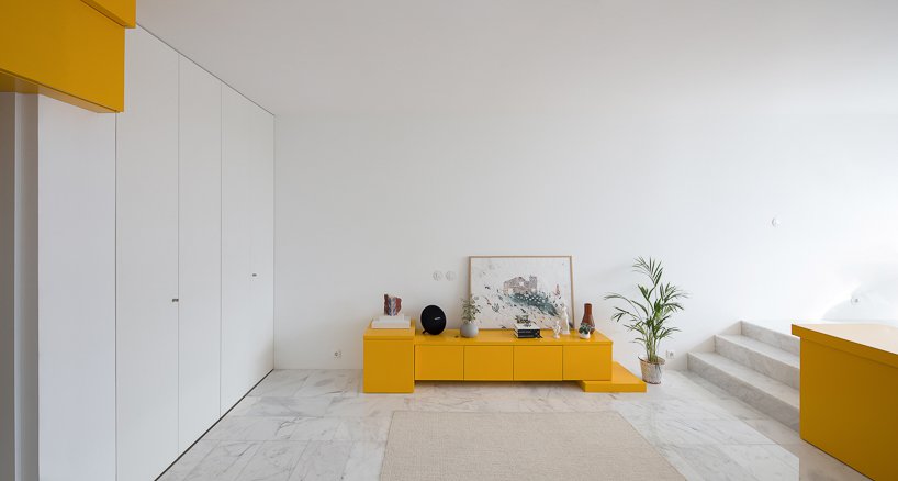 A small storage cabinet in bold yellow in the living room zone is also great for storage