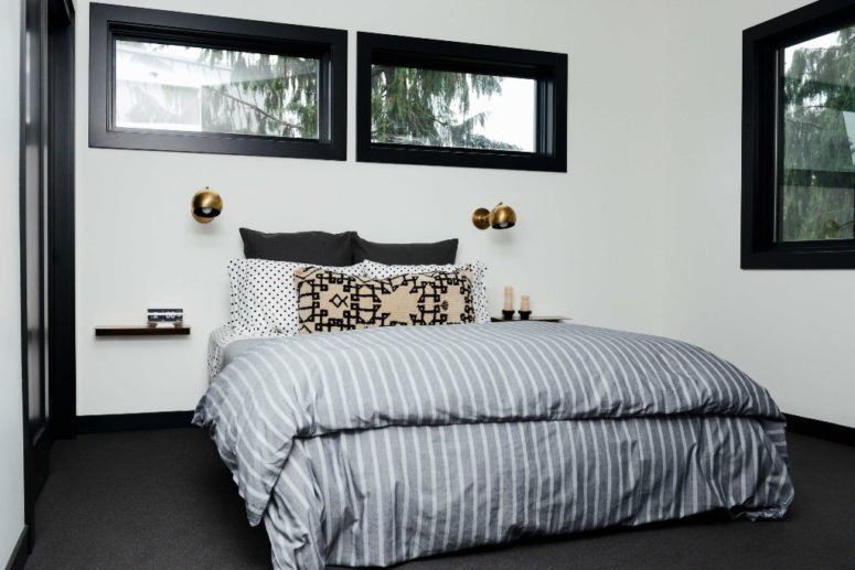 The master bedroom is done with touches of black for more drama and a bed with floating nightstands