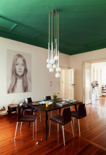 A dining space with a grass green emerald ceiling is a bold color statement that sets the tone