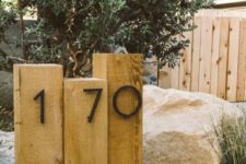 06 wooden posts with metal house numbers integrated right into the landscape is a stylish idea for a modern home