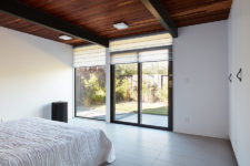 07 A partly glazed wall can be opened to outdoors and covered with Roman shades when the owners want some privacy