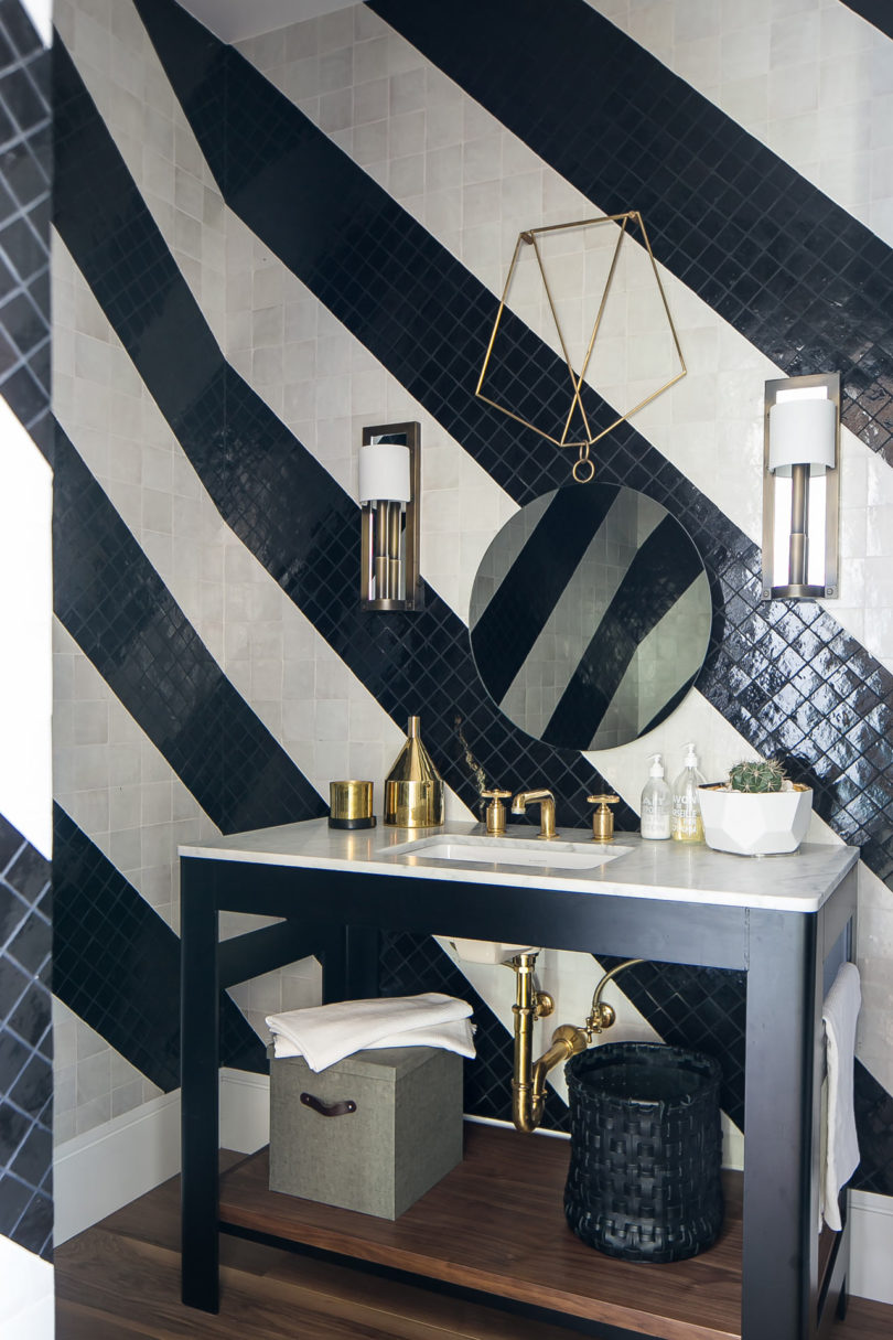 The bathroom is clad with black and white tiles done in stripes
