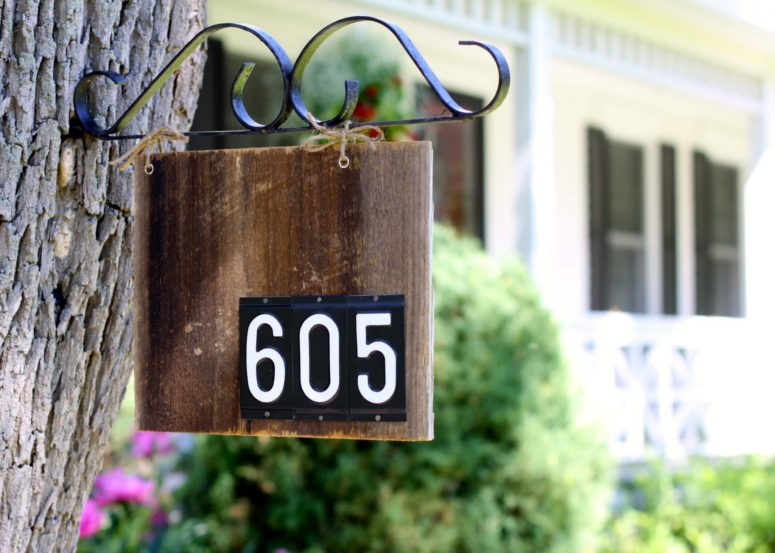 a house number sign hanging from a tree is a stylish vintage-inspired idea for any home