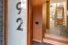08 this front door, with an adjacent large glass panel showcasing the house number, guides visitors into the home