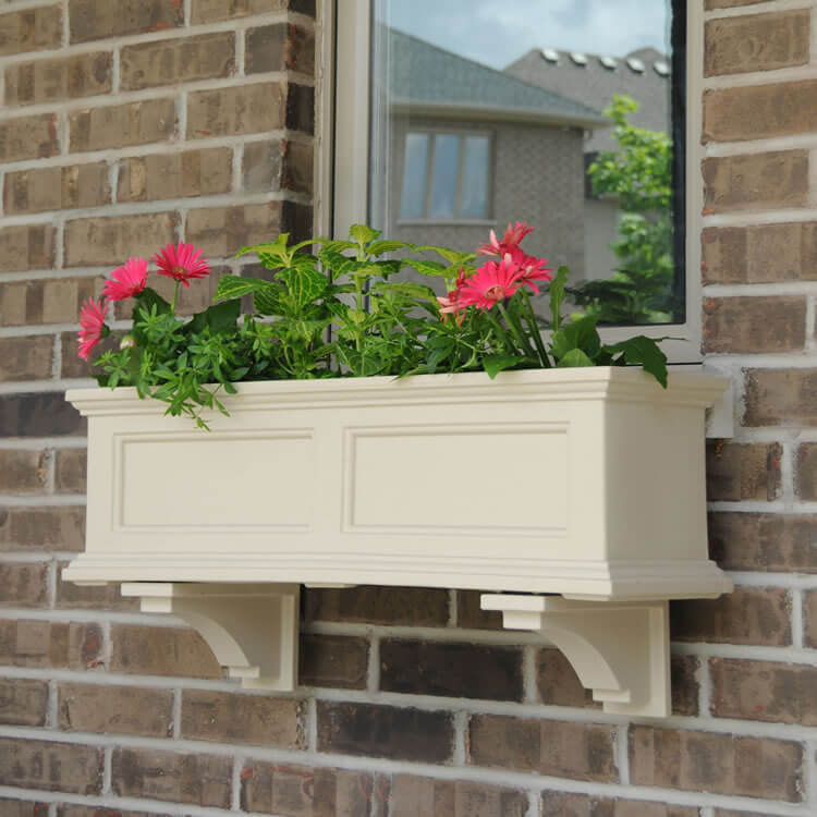 A cream colored molding flower box with pink flowers is a traditional idea to go for