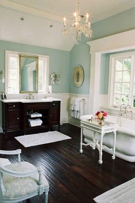 a dark stained floor and a matching vanity are of a dominant dark tone, and the rest of the furniture is whitewashed