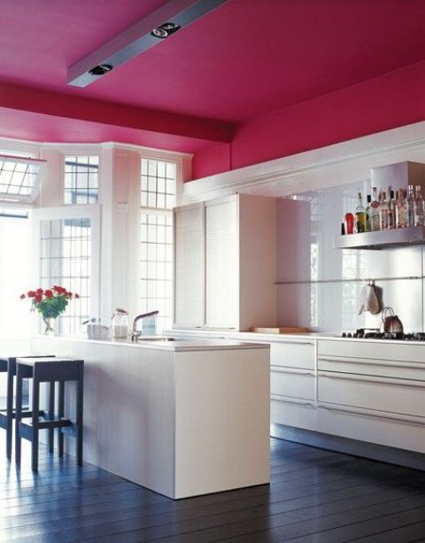 A neutral kitchen highlighted with a burgundy ceiling to visually separate it from the rest of the space