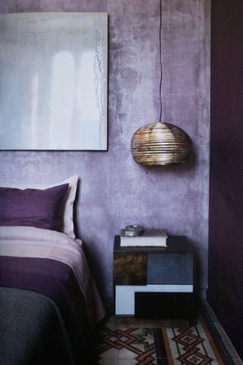 lilac plaster walls and touches of deep purple make up a bold and ultra modern bedroom
