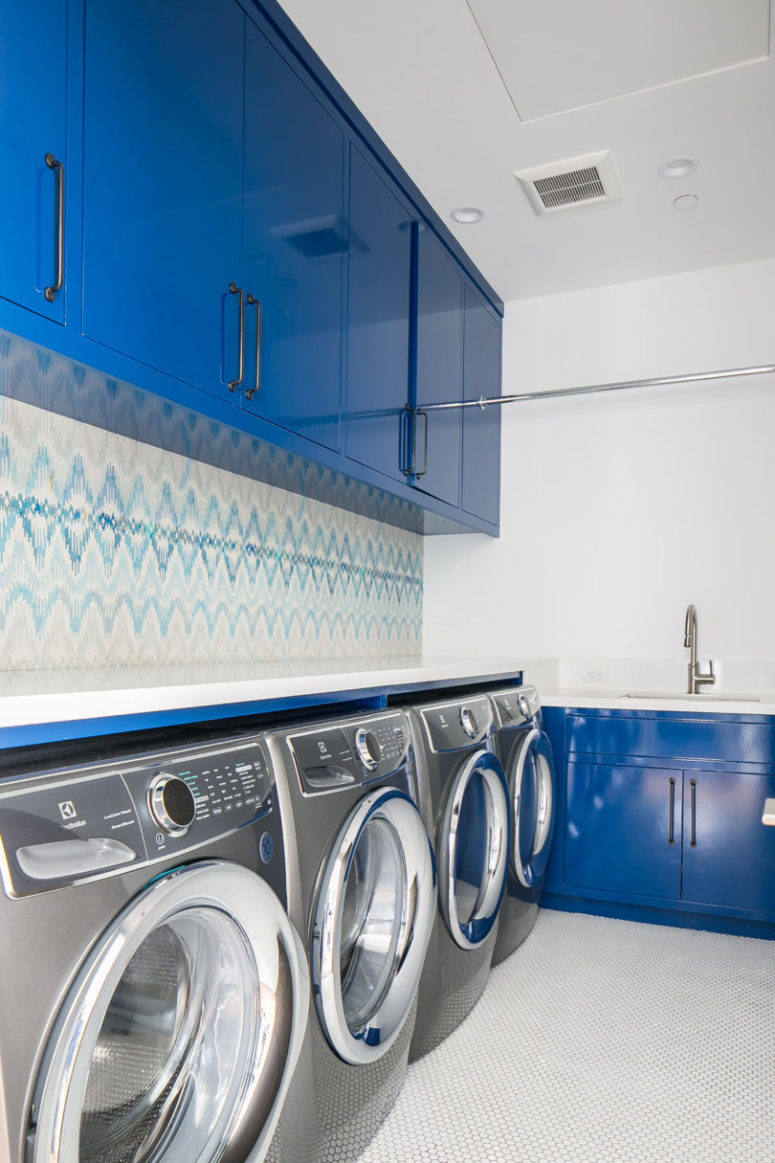 The laundry room continues the blue and white color scheme, which can be seen throughout the house