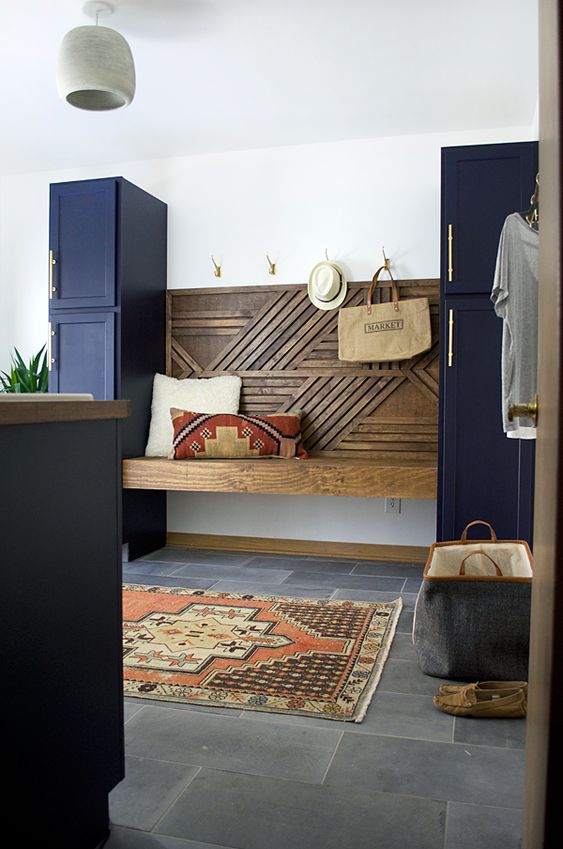 A floating geometric built in bench between two navy cabinets that are secondary ones