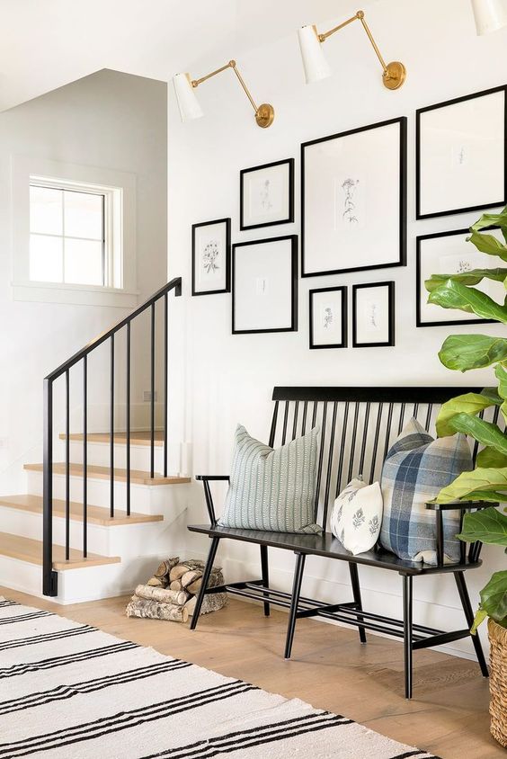a vintage black bench sets the tone of this entryway and printed pillows add to it
