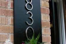 13 a chic black wall planter with numbers and bright blooms and greenery act as an outdoor decoration at the same time