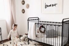 13 a vintage-inspired black iron crib is a refined and chic piece that brings a sophisitcated touch