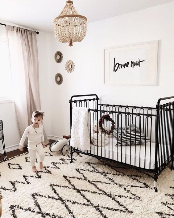 a vintage-inspired black iron crib is a refined and chic piece that brings a sophisitcated touch
