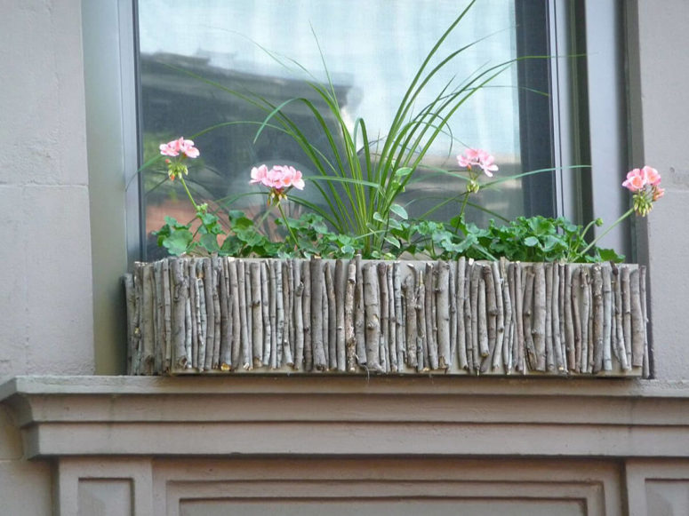 a wig and branch window box with greenery and pink blooms is a great idea to add a natural feel to your window