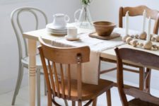 13 totally mismatching wooden chairs and a dining table create a bold and chic look