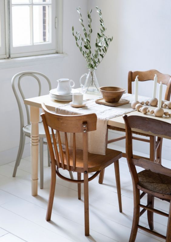 totally mismatching wooden chairs and a dining table create a bold and chic look