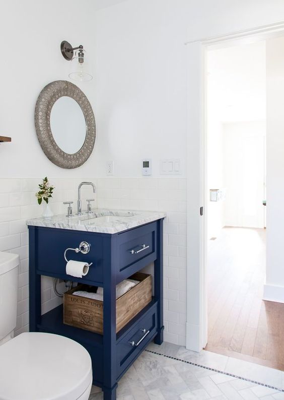 a bright blue small vanity with a stone countertop and some storage space is a bright statement