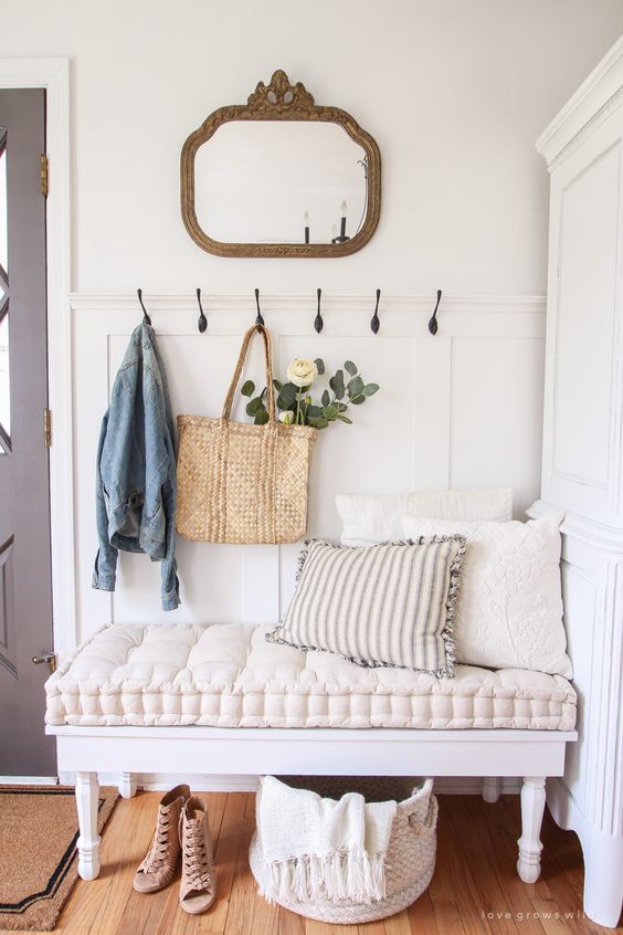 a cozy vintage bench with a super soft cushion gives a tone to this entryway