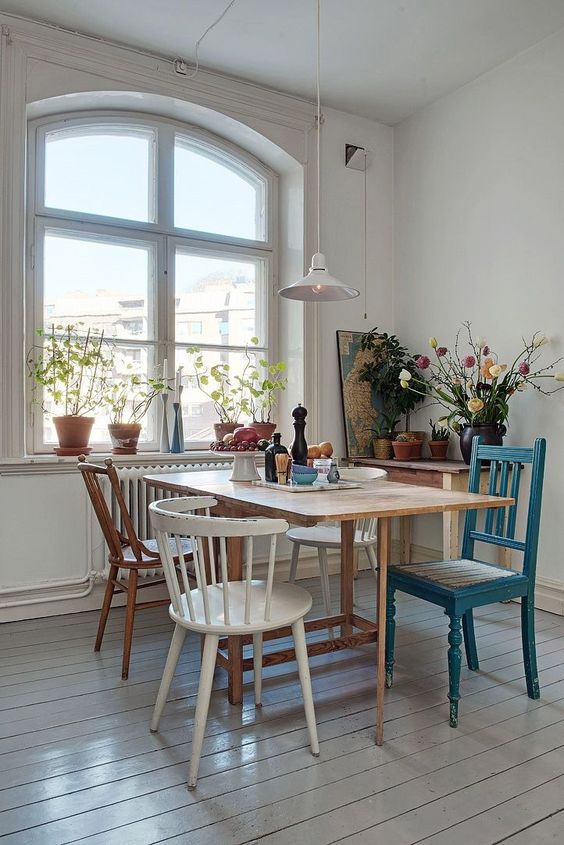 an eclectic dining space with various chairs and a dining table and lots of different finishes