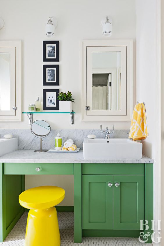 a green vanity and a bold yellow stool is an ultimate combo for a contemporary bathroom
