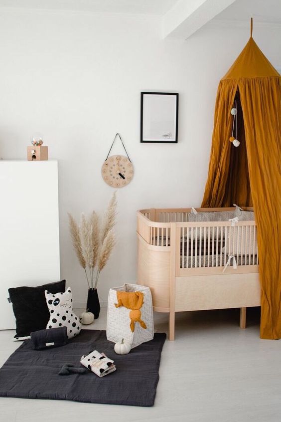 A simple and modern plywood crib with a rust colored canopy for a bold and cool nursery