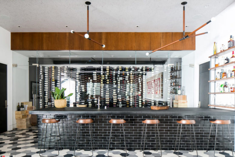 There's a wine cellar clad with glass and a large bar space